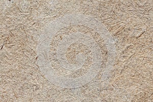 Natural vintage background of organic cardboard with various villi, fluff and other inclusions.