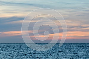 Natural washed pastel cloudscape. Sea and wispy cloud sky at dawn. Soft background image