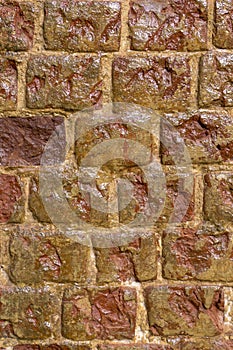 Wet weathered orange brick wall texture made of stone. background, architecture.