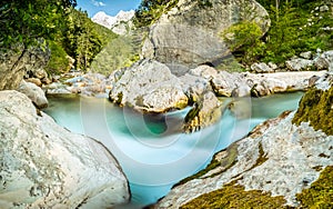 Natural wild river with turquoise water rapids in forest mountain valley.