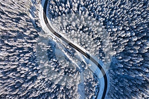 Natural winter landscape from air. Aerial view on the road and forest at the winter time. Winter chill. Forest and snow.
