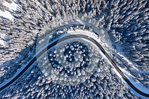 Natural winter landscape from air. Aerial view on the road and forest at the winter time. Winter chill. Forest and snow.