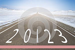 Natural winter snowy landscape with highway leading to New Year's Eve celebration in early 2023