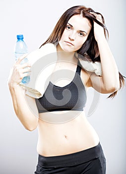 Natural woman after training with water bottle and towel