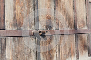 Natural wood doors with rusty metal handles, background.