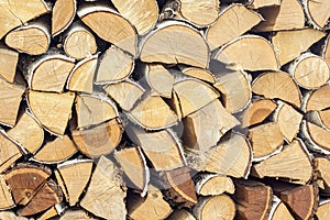 Natural wooden background, closeup of chopped firewood, logs. Chopped firewood on a stack