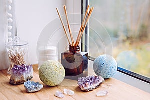 Natural wooden bathroom window sill with liquid diffuser bottle with wood sticks  natural light coming from window. photo