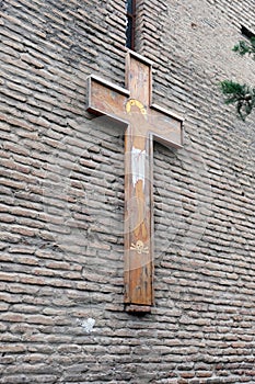 Natural wooden cross on a brick wall.
