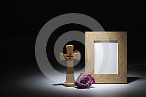 Natural wooden picture frame with wooden crucifix and pink rose