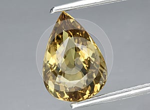 Natural yellow beryl heliodor gem on the background