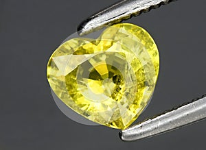 Natural yellow chrysoberyl gem on the background