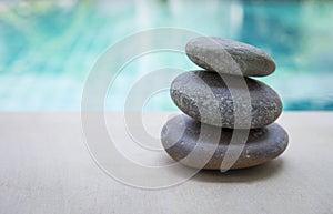 Natural Zen stone stack over blurred blue swimming pool background