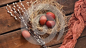 Naturally colored onion husks are Easter eggs in a nest of hay and willow branches. Copy space. Traditions Orthodoxy