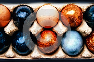 Naturally dyed black, blue, gray, beige, golden Easter eggs pattern.
