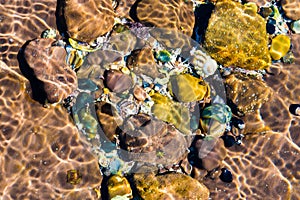 Nature abstract background with colourful rocks in water sand.