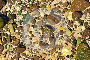 Nature abstract background with colourful rocks in water sand.