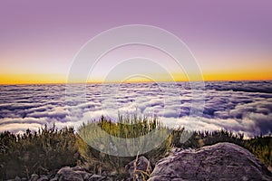 Nature background with sunrise over clouds. It is on the top of Pico do Arieiro mountain, Madeira island, Portugal. The rising sun