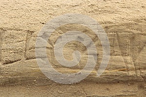 Nature background, texture of a sandstone wall graffiti hieroglyphs carved defaced wall photo