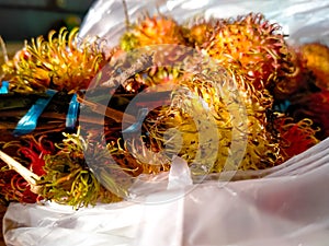 The nature bouquet of & x22;rambutan& x22; is occurring on the white plastic in the market