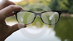 Nature concept, broken glasses, green background, eye glasses, retro style, lens eyeglasses, vision lens, clearly, tinted glasses