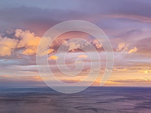 Nature in dusk - beautifull violet sunset over the sea. Pink, violet sky with golden clouds