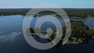 Nature eco landscape with green pines and foliar forest. Drone scenery shot across the rural lake and deciduous trees