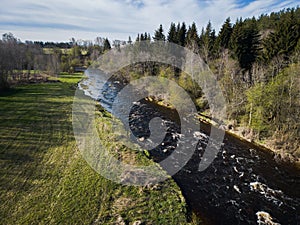 Nature of Estonia. The Pirita River flows through the forest in spring, drone photo