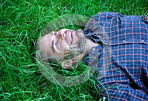 Nature fills him with freshness and inspiration. Man unshaven guy lay on green grass meadow. Guy happy and peaceful