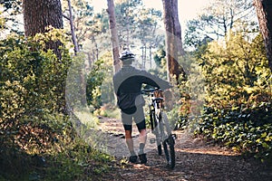 Nature, fitness and man cyclist with a bicycle for cardio training, health or wellness in the woods. Sports, cycle and
