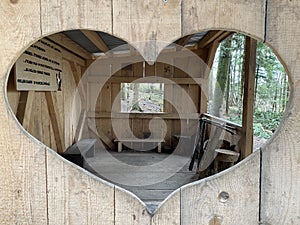 Nature in the heart - a view through the window of a small wooden forest hut at the foot of the Freyenweijer pond - Switzerland