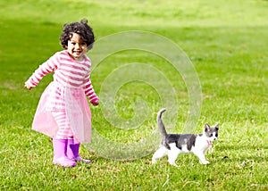 Nature, kitten and girl playing in a garden on the grass on a summer weekend together. Happy, sunshine and portrait of