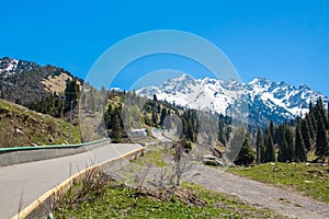 Nature of mountains, green trees and blue sky, road on Medeo in Almaty, Kazakhstan at summer