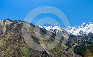 Nature of mountains, snow and blue sky, road on Medeo in Almaty, Kazakhstan, at summer