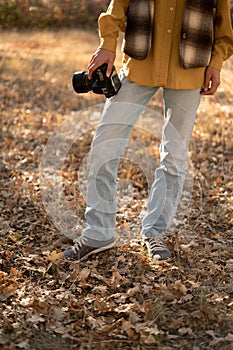 Nature Photography Concept. Professional photographer with dslr camera in autumn forest