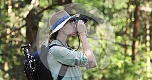 Nature photography - woman photographer taking picture of with analog film camera in forest