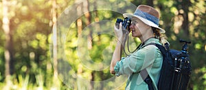 Nature photography - woman photographer taking picture with analog film camera in forest. banner copy space