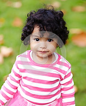 Nature, portrait and girl child in a garden play with toy on the grass on summer weekend. Adorable, playful and young