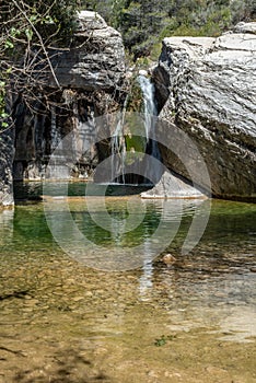 Nature with a river of mineral water and surrounded by gray rocks and green vegetation and plants