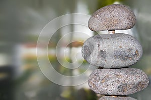 Nature - rocks on a pole close-up to side of image against bokeh blurred green nautral background - room for copy photo