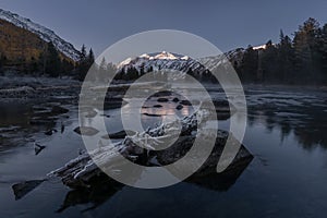 Nature Of Russia. Blue Hour On The Lower Multinsky Lake Near The Spurs Of Katun Ridge. Fallen Frostbitten Tree And Reflecting Whit