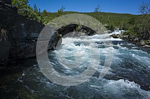 Nature of Scandinavia in summer. Clear water of Abiskojokk river in Abisko National Park