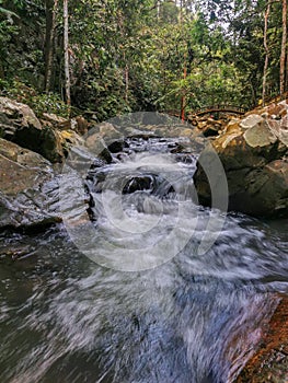 Nature scene featuring beautiful waterfalls showing water streaming through rock crevices on a sunny day