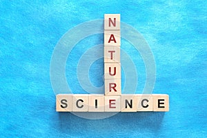 Nature and Science relationship and interconnection concept. Crossword puzzle flat lay in blue background.