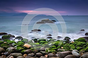 Nature Seascape with Rocks Covered by Green Mosses, Silky Water and Dark Cloudy Sky