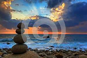 Nature Seascape with Zen Stacked Rocks on Beach at Colorful Sunrise