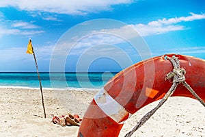 Nature template background with Red lifebuoy and turquoise clear sea and sandy beach in the background. It is symbol of help or