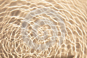 Nature textured background, water waves with sun reflection. Clear water with bubbles and circles on beige background