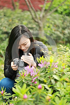 Nature travel photographer woman with Sunshine in spring, looking at carmer screen