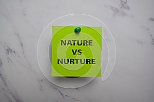 Nature Vs Nurture write on sticky note isolated on Office Desk photo