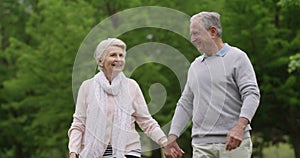 Nature, walking and elderly happy couple holding hands, bonding and outdoor morning journey on park date. Canada